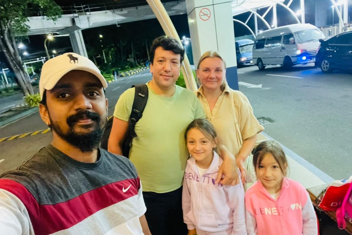 Chauffeur and a family at the airport arrivals hall