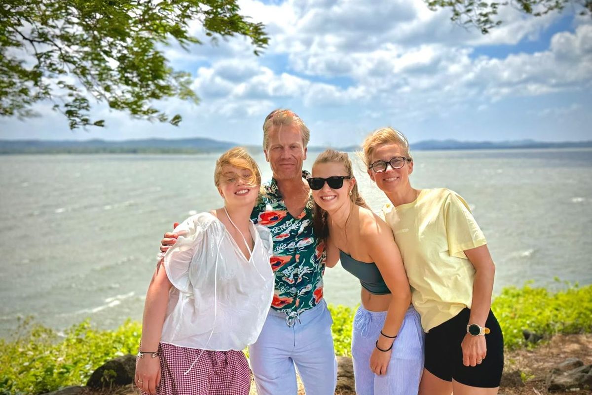 Four travellers smiling beside a lake on a Sri Lanka road trip