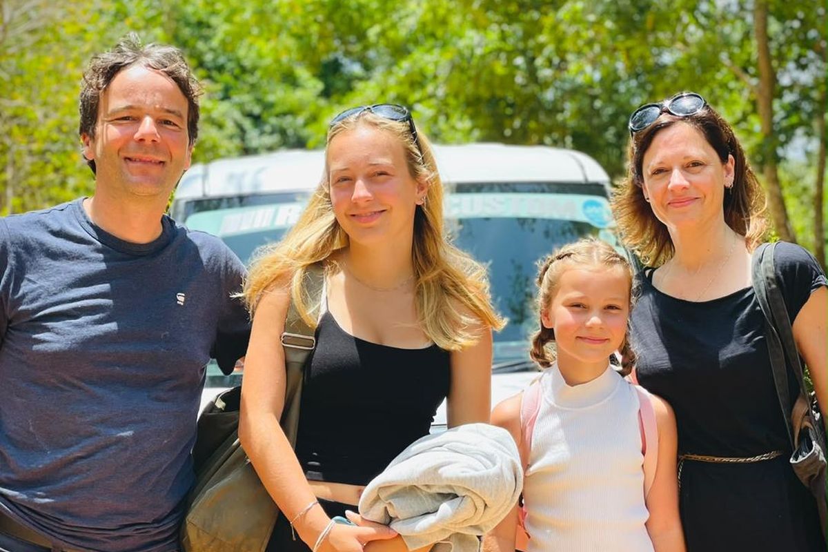 Family with a child standing beside their transfer vehicle