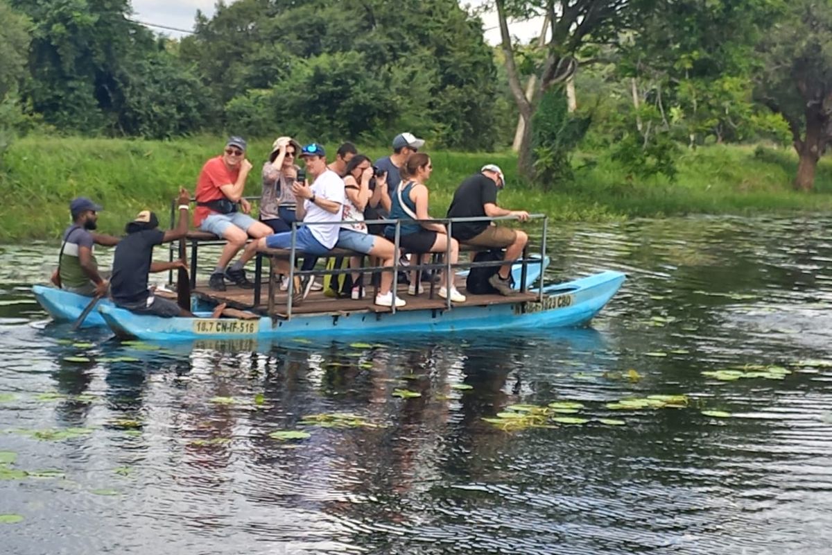 Catamaran carrying a group of guests across a village lake